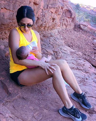 Mom Valerie Castillo feeding baby Journey Castillo with a nursing bottle during one of their first hikes in national parks.