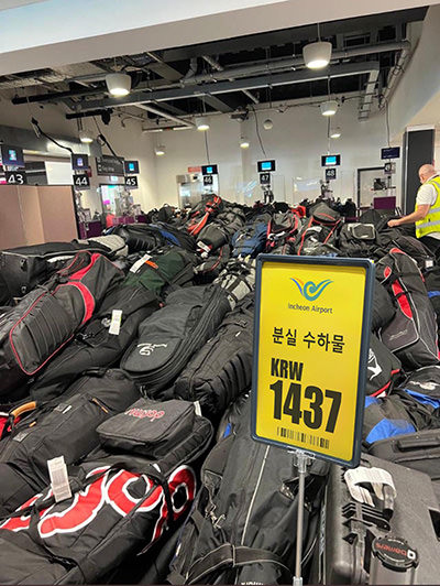 Yellow sign among bags falsely advertising unclaimed baggage sale on Seoul's Incheon Airport; another lost luggage scam trying to trick Facebook users.