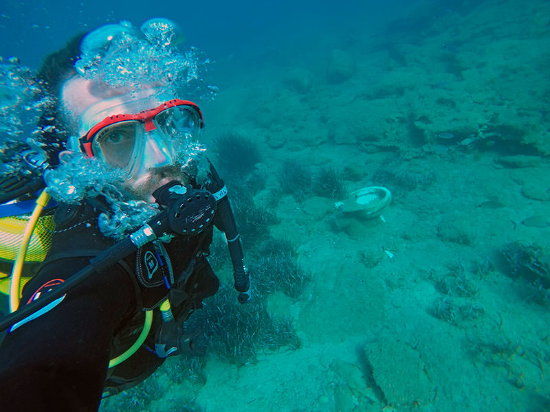 Scuba diving in Naxos, Greece, with toilet seat on the bottom of the sea floor; photo by Ivan Kralj.