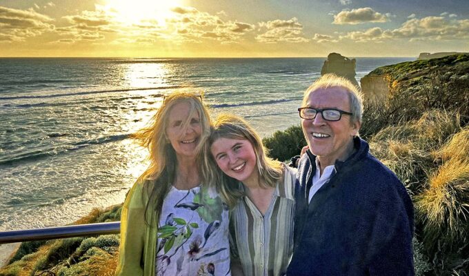 Shannon Coggins, Theo Simon, and their daughter Rosa posing at sunset on their slow travel journey to Australia, a part of their "Buckle Up Dorothy" project to visit a wedding Down Under as no-fly family.