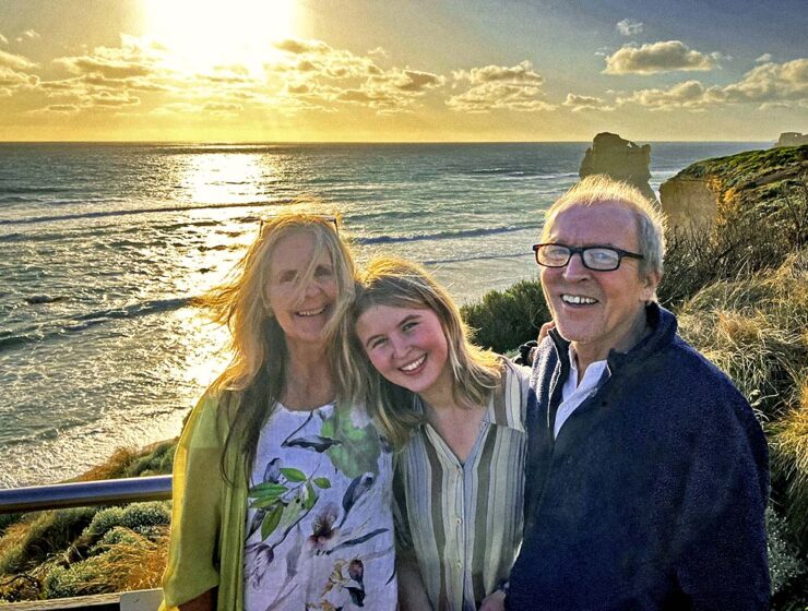 Shannon Coggins, Theo Simon, and their daughter Rosa posing at sunset on their slow travel journey to Australia, a part of their "Buckle Up Dorothy" project to visit a wedding Down Under as no-fly family.