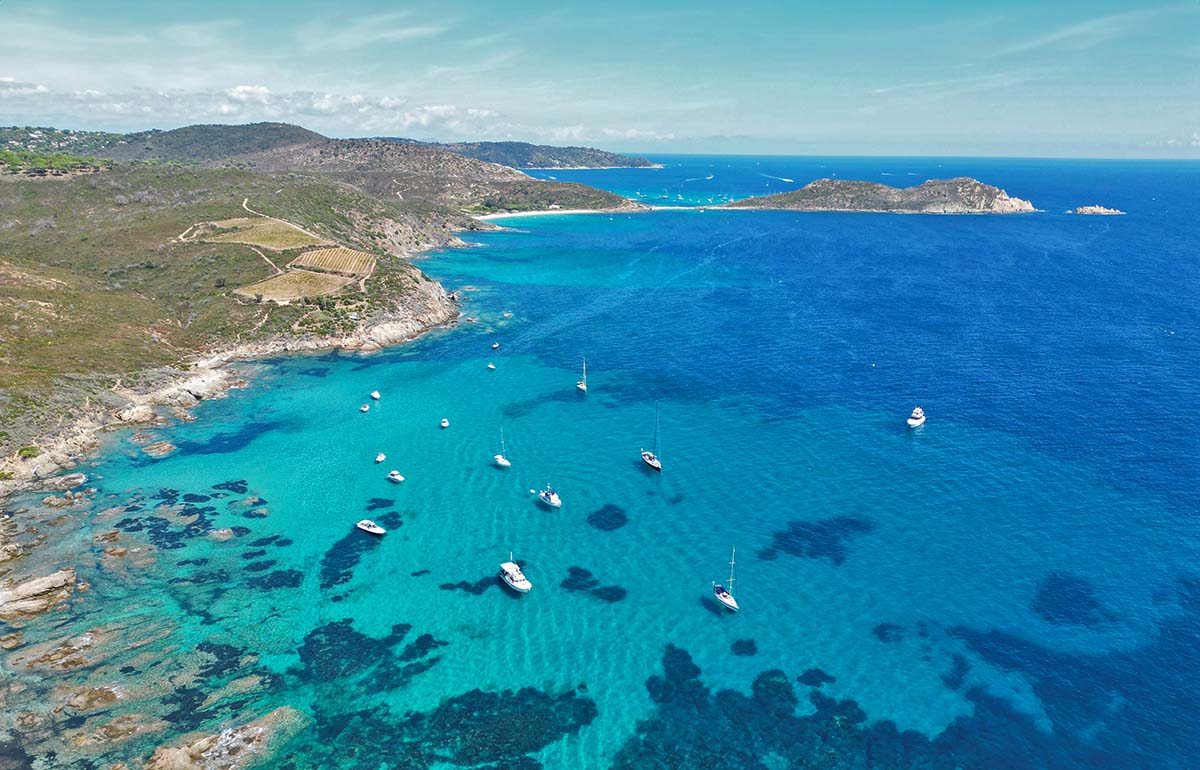 French Riviera or Cote d' Azur, one of the best places to visit in the South of France, aerial view of boats anchored in the azure waters of the coastline; photo by Julius Hildebrandt, Unsplash.