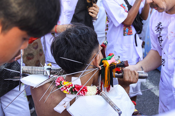 A man with several piercings of his cheek, ears and facial skin at Jor Soo Goong Naka Shrine, during Jay or Phuket Vegetarian Festival, also known as Thailand's self-mutilation festival; photo by Ivan Kralj.