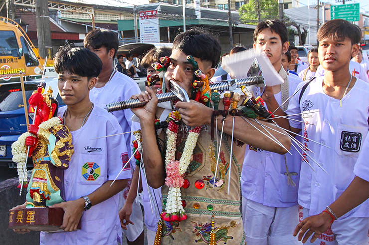 A young man with heavily pierced cheeks walking in a street procession through Phuket during Jay Vegetarian Festival, also known as Thailand's self-mutilation festival; photo by Ivan Kralj.