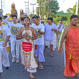 Two ma songs or spirit mediums, one with pierced cheeks and tongue, and the other with pierced arms skin, walking in a street procession through Phuket during Jay or Vegetarian Festival, also known as Thailand's self-mutilation festival; photo by Ivan Kralj.