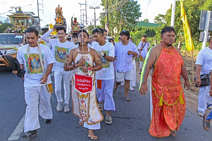 Two ma songs or spirit mediums, one with pierced cheeks and tongue, and the other with pierced arms skin, walking in a street procession through Phuket during Jay or Vegetarian Festival, also known as Thailand's self-mutilation festival; photo by Ivan Kralj.