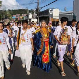 A woman with pierced cheeks, surrounded by other devotees, walking in a street procession through Phuket during Jay or Vegetarian Festival, also known as Thailand's self-mutilation festival; photo by Ivan Kralj.