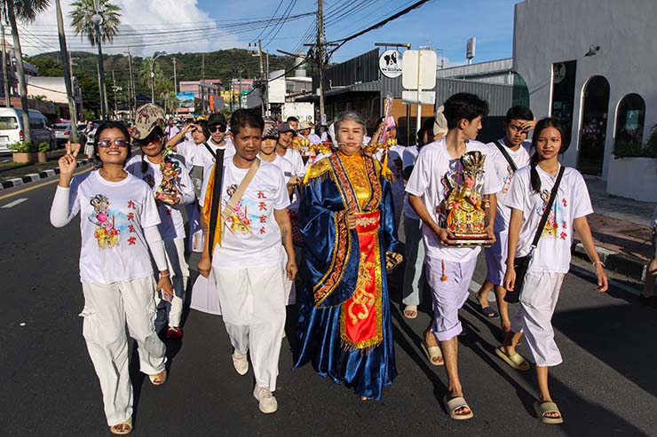 A woman with pierced cheeks, surrounded by other devotees, walking in a street procession through Phuket during Jay or Vegetarian Festival, also known as Thailand's self-mutilation festival; photo by Ivan Kralj.