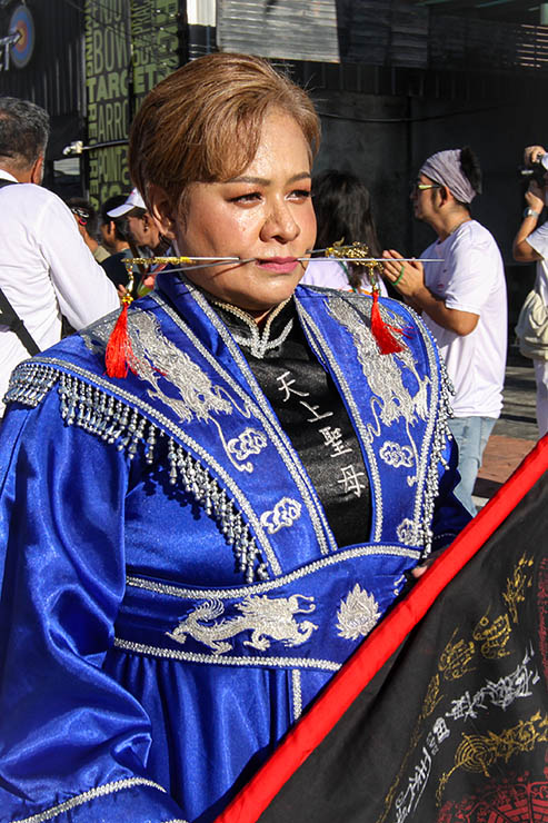 A female ma song (spirit medium) with pierced cheeks, walking in a street procession through Phuket during Jay or Vegetarian Festival, also known as Thailand's self-mutilation festival; photo by Ivan Kralj.