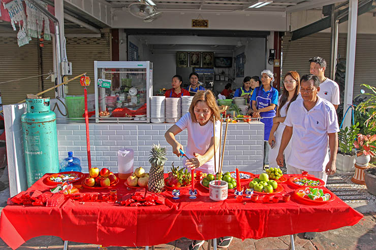 People at a makeshift altar set on the street of Phuket, waiting for the procession of ma song spirit medium to pass by and give their blessings during Jay or Phuket Vegetarian Festival; photo by Ivan Kralj.