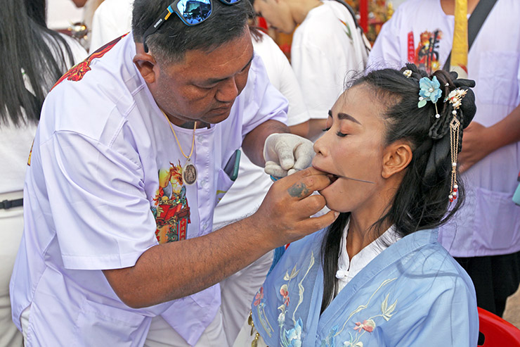 Piercing a woman's cheek at Jor Soo Goong Naka Shrine, during Jay or Phuket Vegetarian Festival, also known as Thailand's self-mutilation festival; photo by Ivan Kralj.