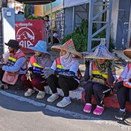 Street cleaners sitting by the road, ready to clean the streets after the procession of Jay or Phuket Vegetarian Festival, known for a widespread use of firecrackers; photo by Ivan Kralj.