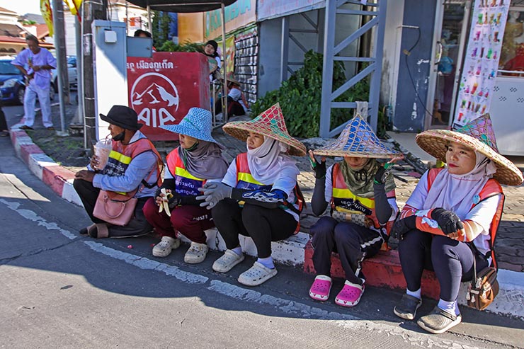 Street cleaners sitting by the road, ready to clean the streets after the procession of Jay or Phuket Vegetarian Festival, known for a widespread use of firecrackers; photo by Ivan Kralj.