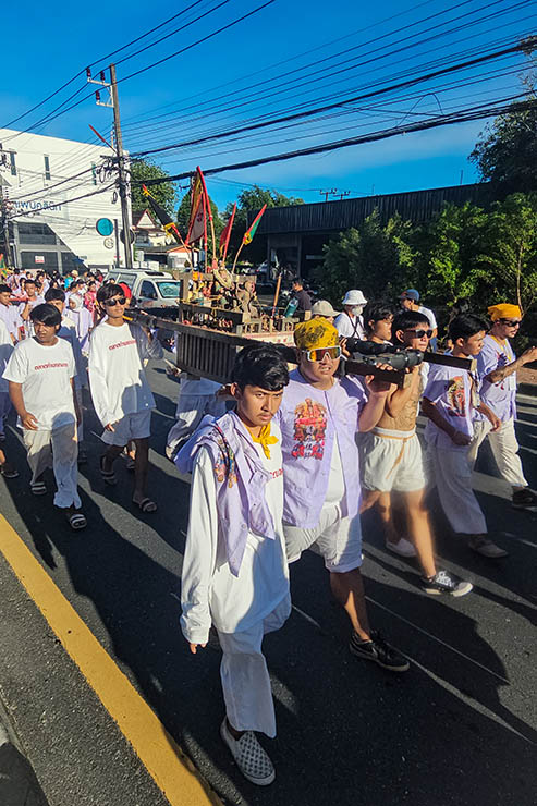 Young men carrying a deity sedan chair through the streets of Phuket, during Jay or Phuket Vegetarian Festival, the festival of Nine Emperor Gods; photo by Ivan Kralj.