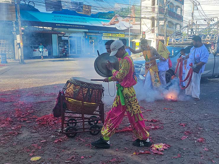 Drummers and a pierced ma song spirit medium walk through the exploding firecrackers in the streets of Phuket, during Jay or Phuket Vegetarian Festival; photo by Ivan Kralj.