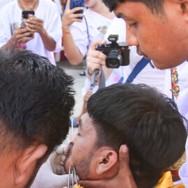 People filming the piercing of a ma song spirit medium at Jor Soo Goong Naka Shrine, during Jay or Phuket Vegetarian Festival, also known as Thailand's self-mutilation festival; photo by Ivan Kralj.