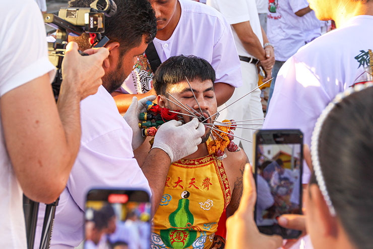 Observers gathering around a ma song spirit medium getting pierced at Jor Soo Goong Naka Shrine, and photographing the act, during Jay or Phuket Vegetarian Festival, also known as Thailand's self-mutilation festival; photo by Ivan Kralj.