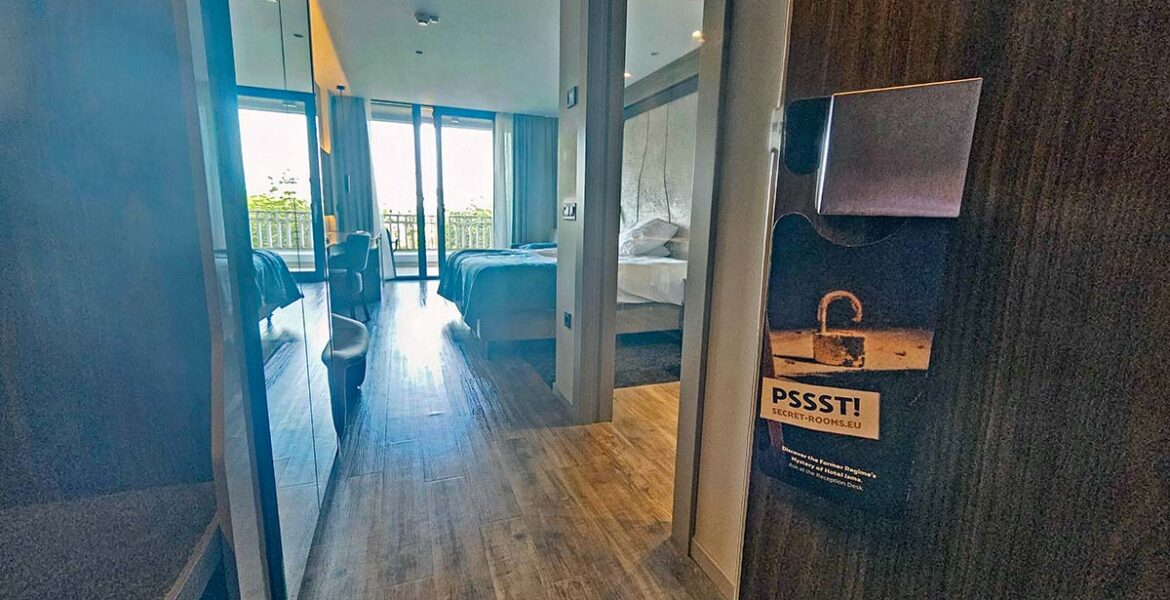 An open door to one of the guest rooms in Hotel Jama, Postojna, Slovenia, with a do-not-disturb sign promoting Secret Rooms, hotel's interactive experience where guests can visit communist-era spy center deep in the hotel's architecture; photo by Ivan Kralj.
