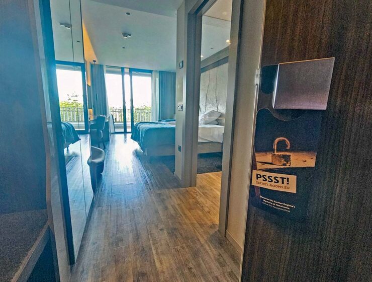 An open door to one of the guest rooms in Hotel Jama, Postojna, Slovenia, with a do-not-disturb sign promoting Secret Rooms, hotel's interactive experience where guests can visit communist-era spy center deep in the hotel's architecture; photo by Ivan Kralj.