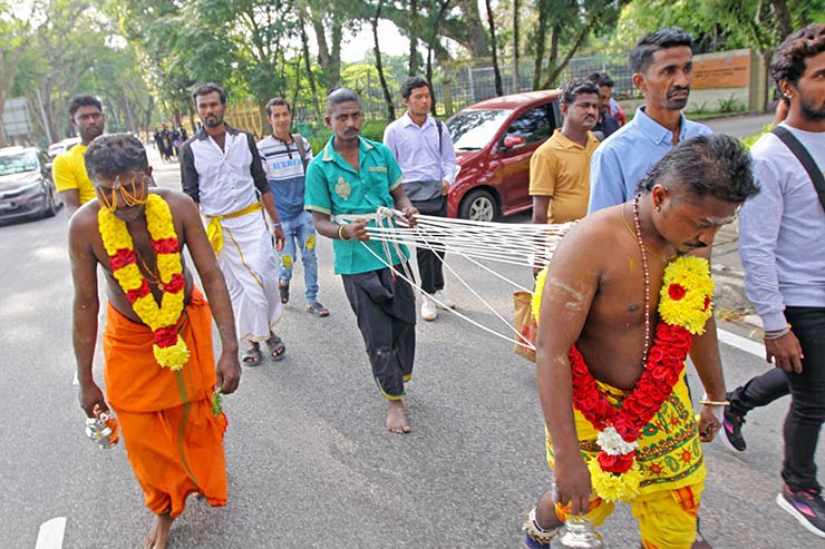 Two Hindu devotees with pierced foreheads, pulling vette mulle kavadi (hooks with attached ropes in the skin of their back) in honor of Lord Murugan, during Thaipusam Festival in Penang, Malaysia; photo by Ivan Kralj.