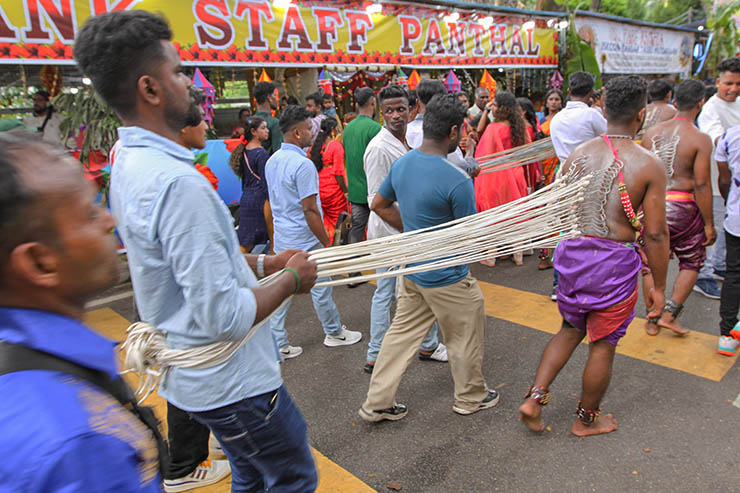 Two Hindu devotees pulling vette mulle kavadi (hooks with attached ropes in the skin of their back) in honor of Lord Murugan, during Thaipusam Festival in Penang, Malaysia; photo by Ivan Kralj.