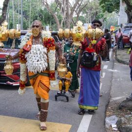 Hindu devotee carrying idumban kavadi (a pole) on his shoulders, and with pierced cheeks and tongue (alavu kavadi) in honor of Lord Murugan, during Thaipusam Festival in Penang, Malaysia; photo by Ivan Kralj.