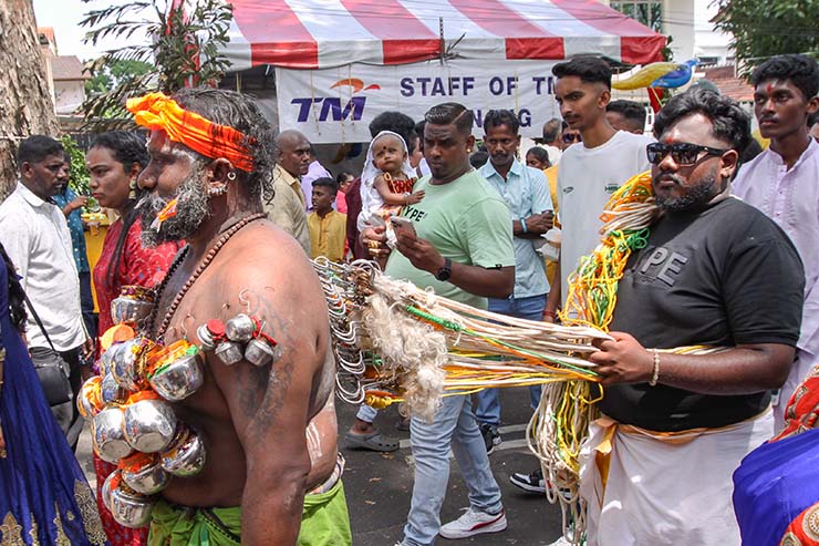 Hindu devotee pulling vette mulle kavadi (hooks with attached ropes in the skin of his back) while carrying koodam mulle kavadi - milk pots pierced on their torso - in honor of Lord Murugan, during Thaipusam Festival in Penang, Malaysia; photo by Ivan Kralj.