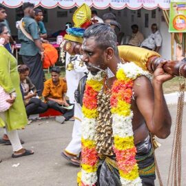 Hindu devotee carrying idumban kavadi (a pole) on his shoulders, and with pierced cheeks (alavu kavadi) in honor of Lord Murugan, during Thaipusam Festival in Penang, Malaysia; photo by Ivan Kralj.
