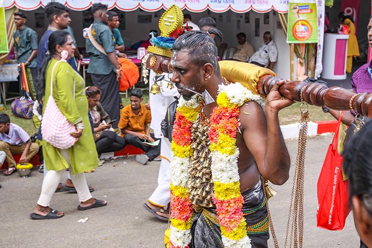 Hindu devotee carrying idumban kavadi (a pole) on his shoulders, and with pierced cheeks (alavu kavadi) in honor of Lord Murugan, during Thaipusam Festival in Penang, Malaysia; photo by Ivan Kralj.
