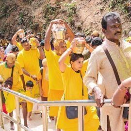 Hindu devotees climbing stairs toward Waterfall Hilltop Temple in Penang, some carrying paal kudam (milk pots) in honor of Lord Murugan for Thaipusam; photo by Ivan Kralj.