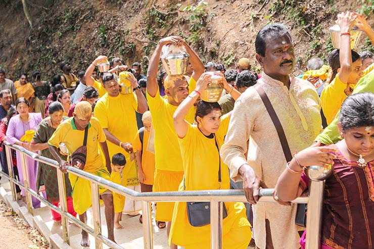 Hindu devotees climbing stairs toward Waterfall Hilltop Temple in Penang, some carrying paal kudam (milk pots) in honor of Lord Murugan for Thaipusam; photo by Ivan Kralj.