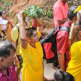 Hindu devotees climbing stairs toward Waterfall Hilltop Temple in Penang, some carrying paal kudam (milk pots), some with pierced cheek, in honor of Lord Murugan for Thaipusam; photo by Ivan Kralj.