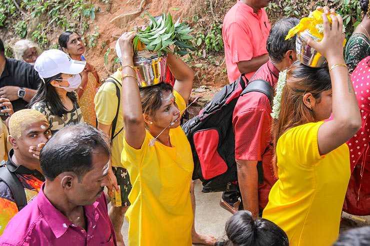 Hindu devotees climbing stairs toward Waterfall Hilltop Temple in Penang, some carrying paal kudam (milk pots), some with pierced cheek, in honor of Lord Murugan for Thaipusam; photo by Ivan Kralj.