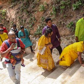Hindu devotees climbing stairs toward Waterfall Hilltop Temple in Penang, Malaysia, one woman doing it on her knees, in honor of Lord Murugan for Thaipusam; photo by Ivan Kralj.