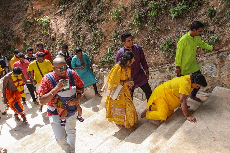 Hindu devotees climbing stairs toward Waterfall Hilltop Temple in Penang, Malaysia, one woman doing it on her knees, in honor of Lord Murugan for Thaipusam; photo by Ivan Kralj.