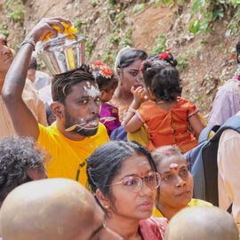 A Hindu man with pierced cheeks carrying a milk pot (paal kudam) on his head during Thaipusam Festival in Penang, Malaysia; photo by Ivan Kralj.