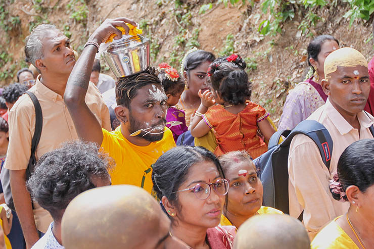 A Hindu man with pierced cheeks carrying a milk pot (paal kudam) on his head during Thaipusam Festival in Penang, Malaysia; photo by Ivan Kralj.