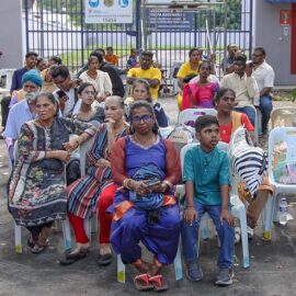 Hindu devotees of different generations sitting in plastic chairs during Thaipusam in Penang, Malaysia; photo by Ivan Kralj.