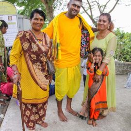 A smiling Hindu family poses for the camera atop the Waterfall Hilltop Temple in Penang, Malaysia, during Thaipusam; photo by Ivan Kralj.