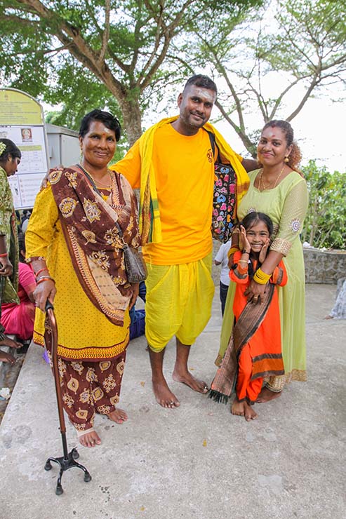 A smiling Hindu family poses for the camera atop the Waterfall Hilltop Temple in Penang, Malaysia, during Thaipusam; photo by Ivan Kralj.