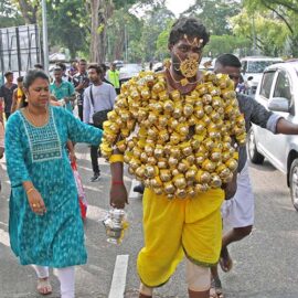 Hindu devotee carrying koodam mulle kavadi - milk pots pierced on his torso, and with forehead and cheeks pierced with little spears (alavu kavadi) in honor of Lord Murugan, during Thaipusam Festival in Penang, Malaysia; photo by Ivan Kralj.
