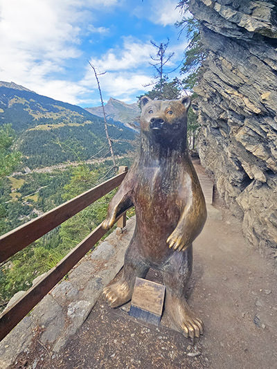 Bronze sculpture of a brown bear by the artist Véronique Olivier, on the Bisse du Torrent Neuf hiking trail in Saviese, Switzerland; photo by Ivan Kralj.