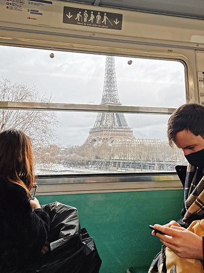 The Eiffel Tower in Paris, France, as seen through a window of a train; photo by Zalfa Imani / Unsplash.