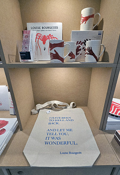 Louise Bourgeois' merchandise such as cups and a tote bag with her quote “I have been to hell and back. And let me tell you, it was wonderful”, displayed on the shelves of the Kunstmuseum Basel gift shop; photo by Ivan Kralj.