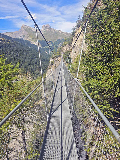 The third suspended bridge on the Bisse du Torrent Neuf hike in Saviese, Switzerland, the longest of four, stretching 97 meters through alpine landscape; photo by Ivan Kralj.