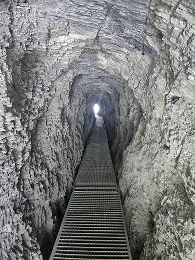 Tunnel du Mougerin, a man-made tunnel through Prabé Mountain, high enough for a person to pass through over the metal grid, following the Bisse du Torrent Neuf stream; photo by Ivan Kralj.