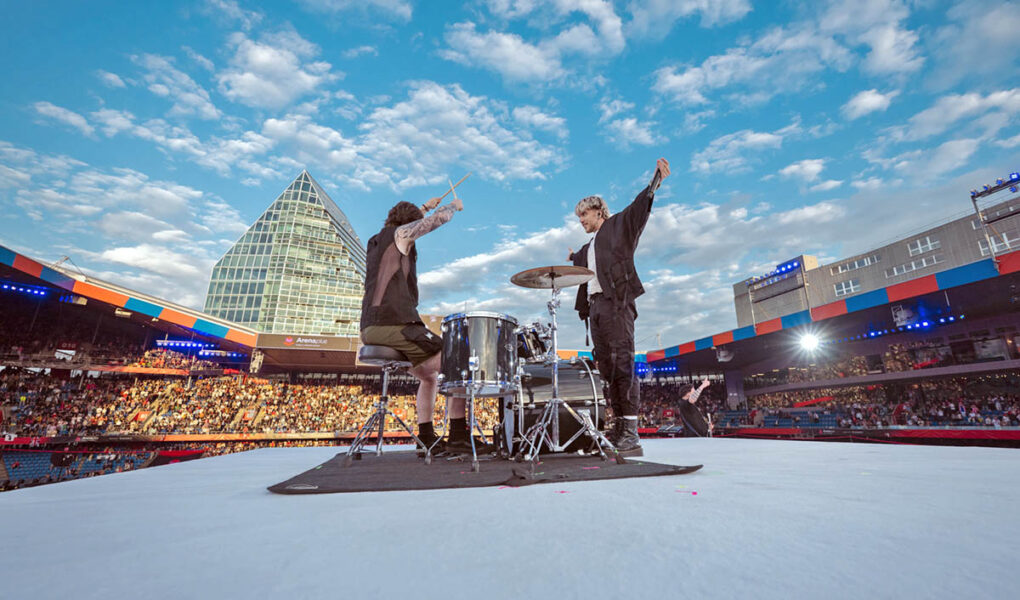Baby Lasagna band, drummer and singer Marko Purišić, performing on the top of a cube stage at St. Jakob-Park stadium during the Arena Plus Eurovision pre-show; credit Kanton Basel-Stadt, photo by Mood Studios AG.