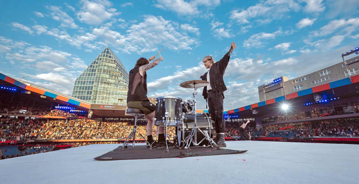 Baby Lasagna band, drummer and singer Marko Purišić, performing on the top of a cube stage at St. Jakob-Park stadium during the Arena Plus Eurovision pre-show; credit Kanton Basel-Stadt, photo by Mood Studios AG.