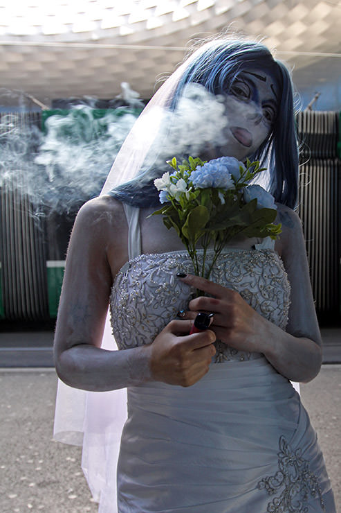 Cosplayer dressed as Tim Burton's Corpse Bride, puffing an e-cigarette smoke at Fantasy Basel, the Swiss Comic Con; photo by Ivan Kralj.
