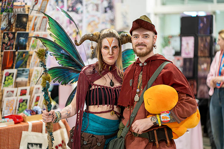 Cosplay visitors of Fantasy Basel with merchandise market behind them; credit Fantasy Basel, the Swiss Comic Con.
